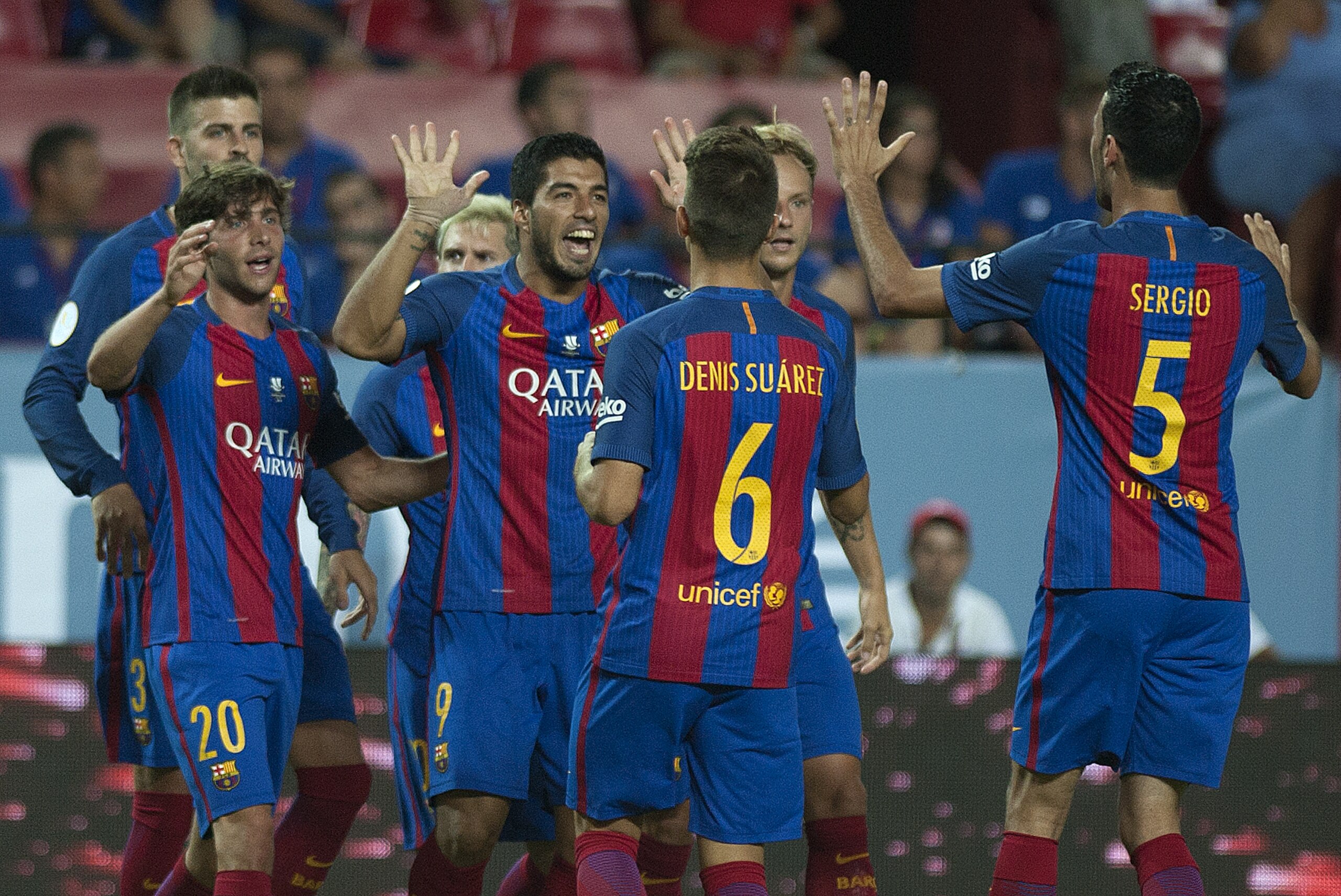 Barcelona's Uruguayan forward Luis alberto Suarez (C) celebrates with his teammates after scoring during the first leg of the Spanish Supercup football match between Sevilla FC and FC Barcelona at the Ramon Sanchez Pizjuan stadium in Sevilla on August 14, 2016. / AFP / JORGE GUERRERO        (Photo credit should read JORGE GUERRERO/AFP/Getty Images)