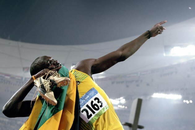 Jamaica's Usain Bolt celebrates winning the men's 200m final at the 'Bird's Nest' National Stadium during the 2008 Beijing Olympic Games on August 20, 2008. Bolt became the first man in 24 years to claim the Olympic sprint double when he won the 200m in a new world record time of 19.30sec. Netherlands Antilles' Churandy Martina claimed silver in 19.82sec as Wallace Spearmon crossed the line third but was disqualified, handing the bronze medal to 2004 Olympic champion Shawn Crawford in 19.96.  AFP PHOTO/DDP/MICHAEL KAPPELER (Photo credit should read MICHAEL KAPPELER/AFP/Getty Images)