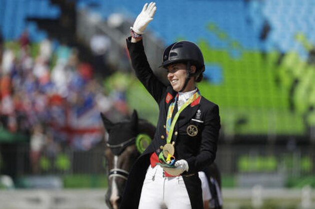 Britain's Charlotte Dujardin reacts on the podium after winning a gold medal in the equestrian dressage individual competition at the 2016 Summer Olympics in Rio de Janeiro, Brazil, Monday, Aug. 15, 2016. (AP Photo/John Locher)