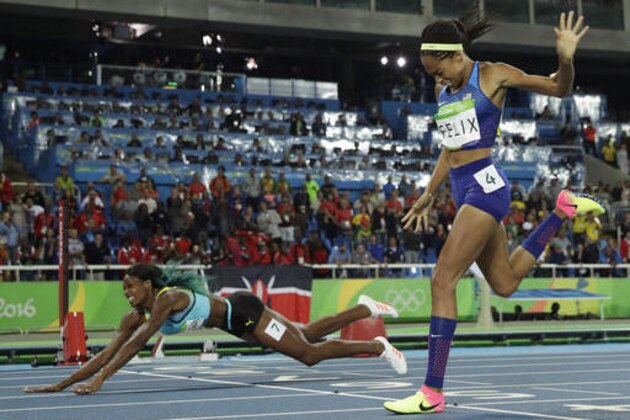 Bahamas' Shaunae Miller falls over the finish line to win gold ahead of United States' Allyson Felix, right, in the women's 400-meter final during the athletics competitions of the 2016 Summer Olympics at the Olympic stadium in Rio de Janeiro, Brazil, Monday, Aug. 15, 2016. (AP Photo/Matt Slocum)