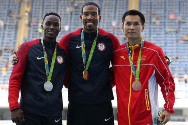 United States' gold medal winner Christian Taylor is flanked by United States' silver medal winner Will Claye, left, and China's bronze medal winner Dong Bin during the medal ceremony for the men's triple jump during the athletics competitions of the 2016 Summer Olympics at the Olympic stadium in Rio de Janeiro, Brazil, Tuesday, Aug. 16, 2016. (AP Photo/Lee Jin-man)