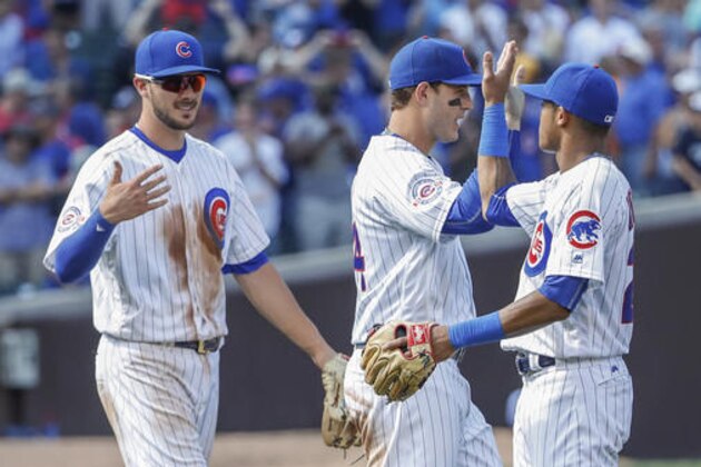 Chicago Cubs' Addison Russell, right, celebrates with Anthony Rizzo, center, and Kris Bryant, left, after the team's 4-0 win against the Milwaukee Brewers in a baseball game, Tuesday, Aug. 16, 2016, at Wrigley Field in Chicago. (AP Photo/Kamil Krzaczynski)