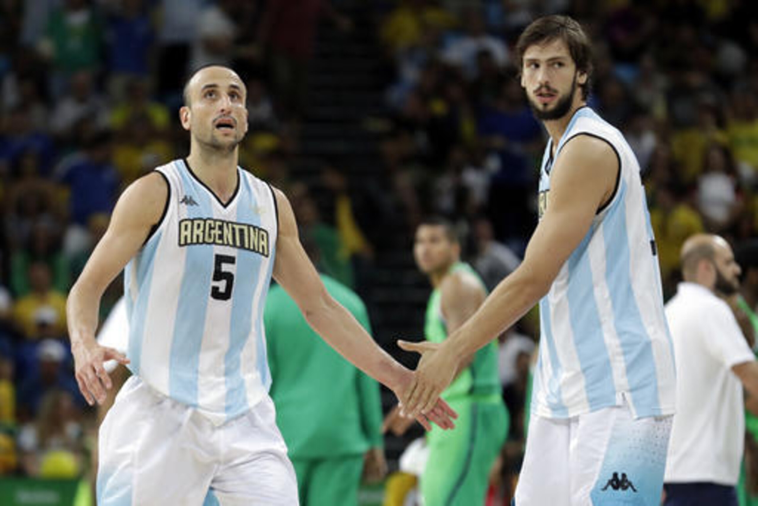 Argentina's Manu Ginobili (5) reacts with teammate Marcos Delia, right, during a basketball game against Brazil at the 2016 Summer Olympics in Rio de Janeiro, Brazil, Saturday, Aug. 13, 2016. Argentina won 111-107 in double overtime. (AP Photo/Charlie Neibergall)