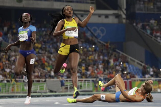 Second placed Netherlands' Dafne Schippers, right, falls over the finish line as Elaine Thompson from Jamaica, center, wins the gold and United States' Tori Bowie, left, places third in the women's 200-meter final during the athletics competitions of the 2016 Summer Olympics at the Olympic stadium in Rio de Janeiro, Brazil, Wednesday, Aug. 17, 2016. (AP Photo/David J. Phillip)