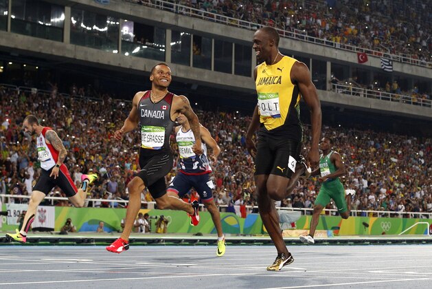 Canada's Andre De Grasse and Jamaica's Usain Bolt cross the finish line in the Men's 200m Semifinal during the athletics event at the Rio 2016 Olympic Games at the Olympic Stadium in Rio de Janeiro on August 17, 2016.   / AFP / Adrian DENNIS        (Photo credit should read ADRIAN DENNIS/AFP/Getty Images)