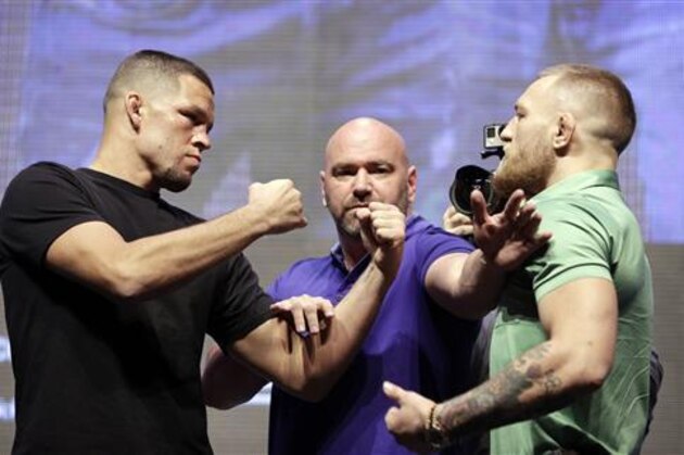 Dana White, center, stands between Nate Diaz, left, and Conor McGregor during a UFC 202 mixed martial arts news conference, Thursday, July 7, 2016, in Las Vegas. Diaz and McGregor are scheduled to fight at UFC 202 in Las Vegas. (AP Photo/John Locher)
