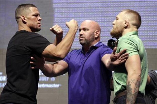 Dana White, center, stands between Nate Diaz, left, and Conor McGregor during a UFC 202 mixed martial arts news conference, Thursday, July 7, 2016, in Las Vegas. Diaz and McGregor are scheduled to fight at UFC 202 in Las Vegas. (AP Photo/John Locher)