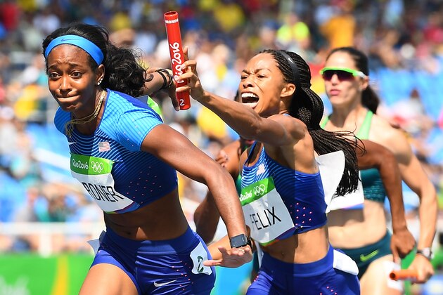 USA's Allyson Felix hands the baton to USA's English Gardner competes in the Women's 4 x 100m Relay Round 1 during the athletics event at the Rio 2016 Olympic Games at the Olympic Stadium in Rio de Janeiro on August 18, 2016.   / AFP / FRANCK FIFE        (Photo credit should read FRANCK FIFE/AFP/Getty Images)