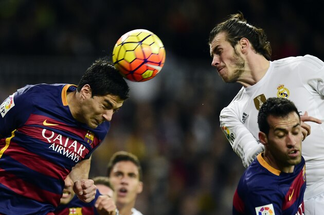 Barcelona's Uruguayan forward Luis Suarez heads the ball next to Real Madrid's Welsh forward Gareth Bale (R top) and teammate Barcelona's midfielder Sergio Busquets (R bottom) during the Spanish league 'Clasico' football match Real Madrid CF vs FC Barcelona at the Santiago Bernabeu stadium in Madrid on November 21, 2015. AFP PHOTO/ JAVIER SORIANO / AFP / JAVIER SORIANO        (Photo credit should read JAVIER SORIANO/AFP/Getty Images)