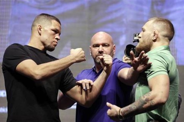 Dana White, center, stands between Nate Diaz, left, and Conor McGregor during a UFC 202 mixed martial arts news conference, Thursday, July 7, 2016, in Las Vegas. Diaz and McGregor are scheduled to fight at UFC 202 in Las Vegas. (AP Photo/John Locher)