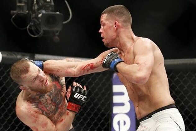 Conor McGregor, left, trades punches with Nate Diaz during their UFC 196 welterweight mixed martial arts match, Saturday, March 5, 2016, in Las Vegas. (AP Photo/Eric Jamison)