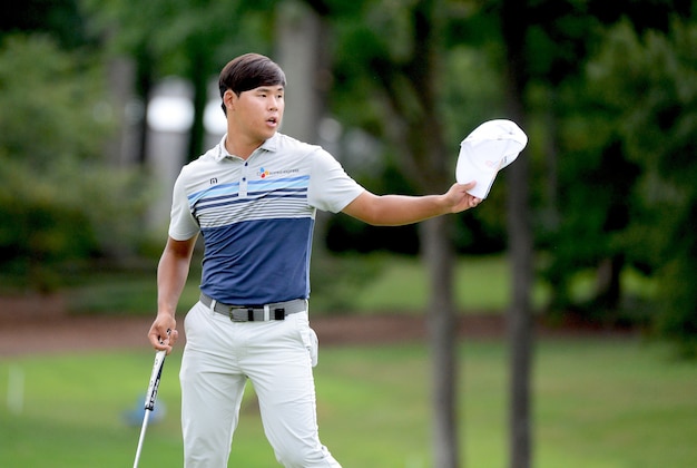 Aug 19, 2016; Greensboro, NC, USA; Si Woo Kim acknowledges the crowd on the ninth green after shooting a tournament record 60 during the second round of the 2016 Wyndham Championship. at Sedgefield Country Club. Mandatory Credit: Rob Kinnan-USA TODAY Sports