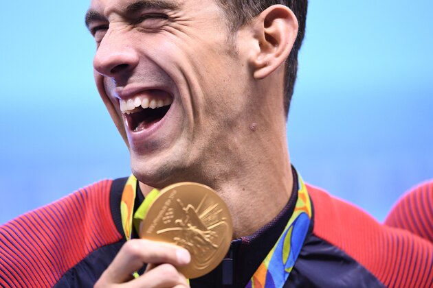 TOPSHOT - USA's Michael Phelps poses with his gold medal during the podium ceremony of the Men's swimming 4 x 100m Medley Relay Final at the Rio 2016 Olympic Games at the Olympic Aquatics Stadium in Rio de Janeiro on August 13, 2016.  
Michael Phelps brought down the curtain on his glittering Olympic career when he helped the USA win 4x100m medley relay gold at the Rio Games on Saturday, taking his personal tally to 23. / AFP / GABRIEL BOUYS        (Photo credit should read GABRIEL BOUYS/AFP/Getty Images)