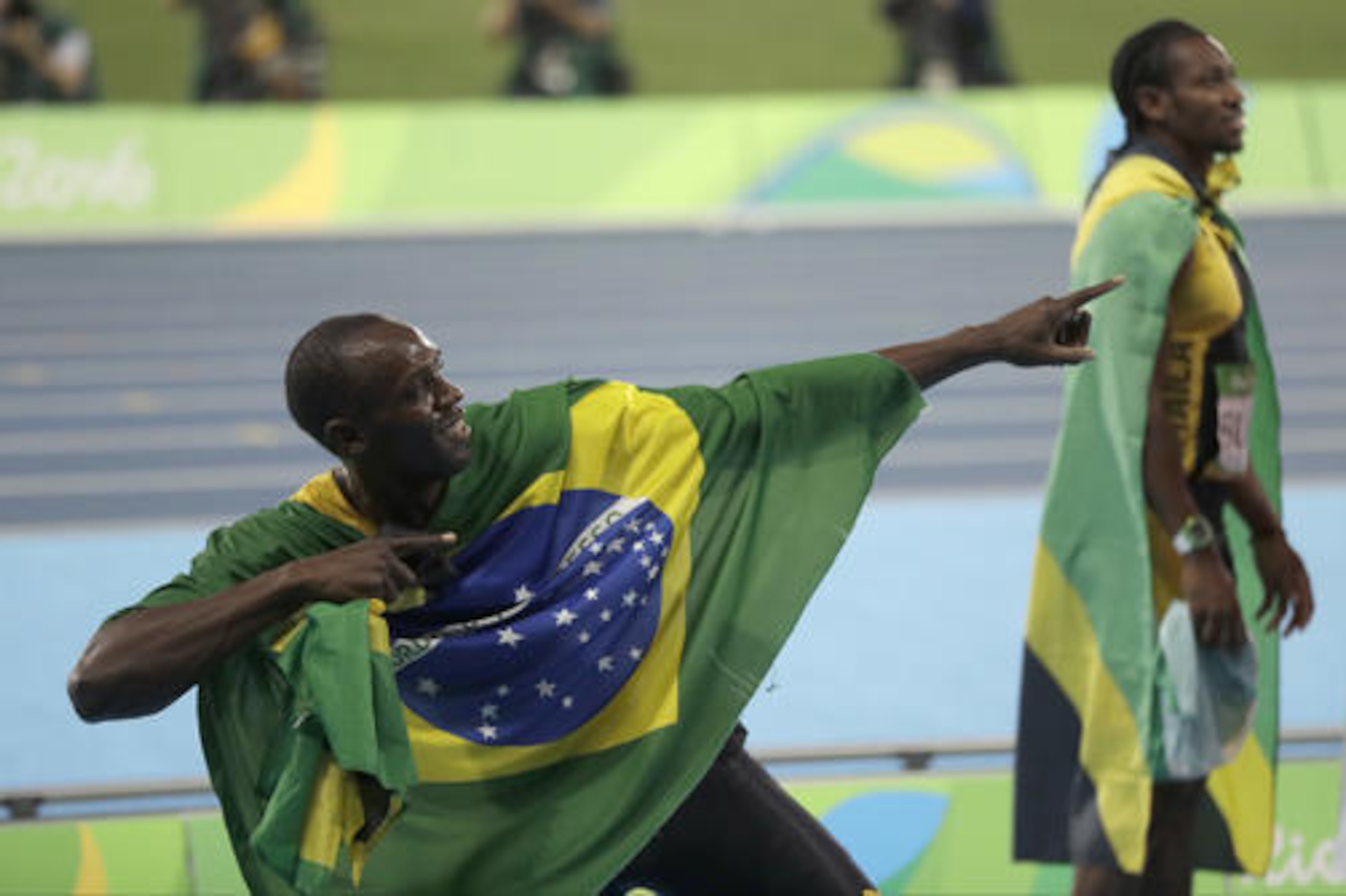 Jamaica's Usain Bolt holds the flag of Brazil after winning the gold medal in the men's 4x100-meter relay final during the athletics competitions of the 2016 Summer Olympics at the Olympic stadium in Rio de Janeiro, Brazil, Friday, Aug. 19, 2016. (AP Photo/David Goldman)