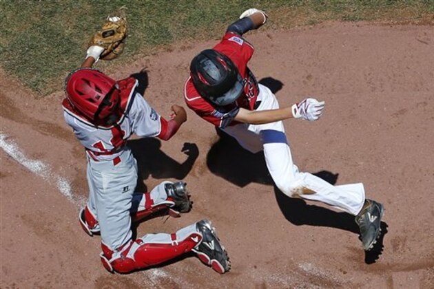 Japan's catcher Akira Jozawa, left, tags out Canada's Sean Coventry who was attempting to score during the first inning of an International pool play baseball game at the Little League World Series tournament in South Williamsport, Pa., Friday, Aug. 19, 2016. Canada won 10-4. (AP Photo/Gene J. Puskar)