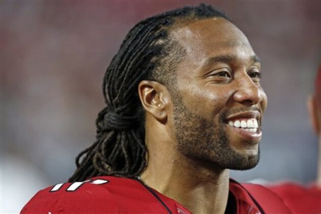 Arizona Cardinals' Larry Fitzgerald smiles as he talks with teammates on the sidelines during the second half of an NFL preseason football game against the Oakland Raiders Friday, Aug. 12, 2016, in Glendale, Ariz.  The Raiders defeated the Cardinals 31-10. (AP Photo/Ross D. Franklin)