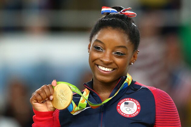 RIO DE JANEIRO, BRAZIL - AUGUST 16:  Gold medalist Simone Biles of the United States celebrates on the podium at the medal ceremony for the Women's Floor on Day 11 of the Rio 2016 Olympic Games at the Rio Olympic Arena on August 16, 2016 in Rio de Janeiro, Brazil.  (Photo by Alex Livesey/Getty Images)
