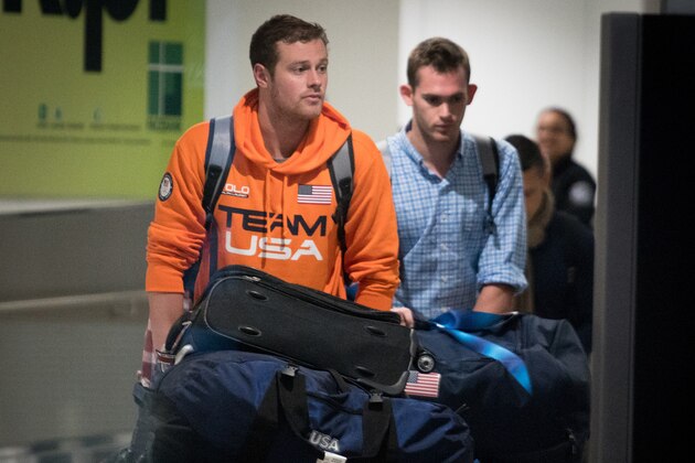 MIAMI, FL - AUGUST 19: USA National Swimming Team members Jack Conger (L) and Gunnar Bentz are escorted through the International terminal at Miami International Airport upon their arrival to the United States from Rio de Janeiro, Brazil on August 19, 2016 in Miami, Florida. Ryan Lochte, Gunnar Bentz, Jack Conger and Jimmy Feigen were involved in an altercation at a gas station in Rio on Sunday. Bentz and Conger were detained by Brazilian authorities while attempting to fly out of Brazil on August 17. Their claims of being victims of a late-night robbery are being questioned by police. (Photo by Angel Valentin/Getty Images)