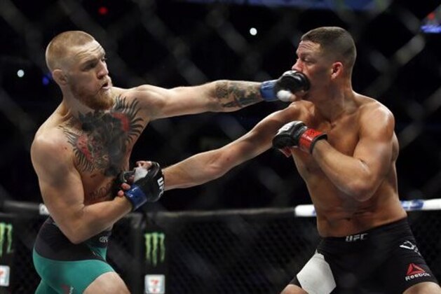 Conor McGregor, left, punches Nate Diaz during their welterweight mixed martial arts bout at UFC 202 on Saturday, Aug. 20, 2016, in Las Vegas. McGregor won by split decision. (AP Photo/Isaac Brekken)