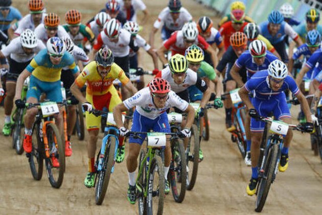 Cyclists, Marco Aurelio Fontana of Italy (7), Victor Koretzky of France (5), Daniel McConnell of Austria (11) and Nino Schurter of Switzerland (3) lead at the start of the men's cross-country cycling mountain bike race at the 2016 Summer Olympics in Rio de Janeiro, Brazil, Saturday, Aug. 20, 2016. (AP Photo/Patrick Semansky)