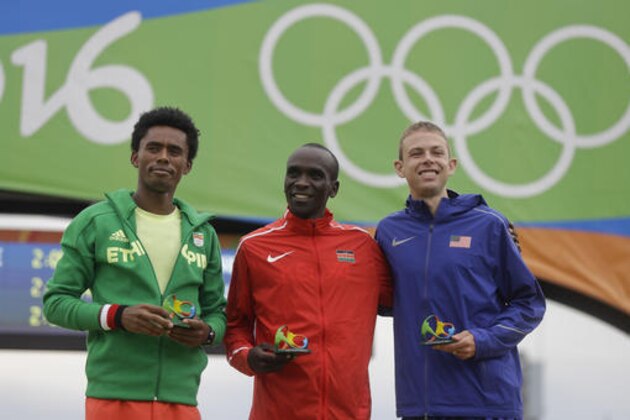 Kenya's Eliud Kipchoge, center, gold medal, celebrates on the podium flanked by silver medal Ethiopia's Feyisa Lilesa, left, and bronze medal U.S. Galen Rupp after the men's marathon at the 2016 Summer Olympics in Rio de Janeiro, Brazil, Sunday, Aug. 21, 2016. (AP Photo/Luca Bruno)