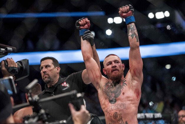 Aug 20, 2016; Las Vegas, NV, USA; Conor McGregor (blue gloves) reacts to fight with Nate Diaz (red gloves) during UFC 202 at T-Mobile Arena. Mandatory Credit: Joshua Dahl-USA TODAY Sports