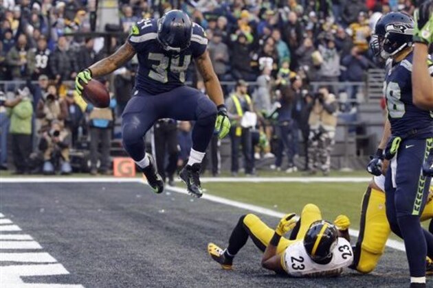 Seattle Seahawks' Thomas Rawls (34) jumps after scoring a touchdown as Pittsburgh Steelers' Mike Mitchell lies in the end zone in the second half of an NFL football game, Sunday, Nov. 29, 2015, in Seattle. (AP Photo/Ted S. Warren)