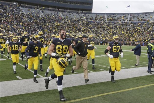 Michigan head coach Jim Harbaugh leads the Michigan team to the locker room before the first half of an NCAA college football game against Ohio State, Saturday, Nov. 28, 2015, in Ann Arbor, Mich. (AP Photo/Carlos Osorio)