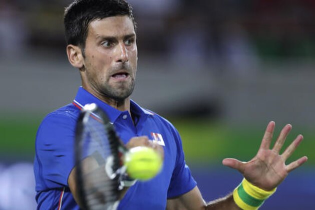 Novak Djokovic, of Serbia, returns to Juan Martin del Potro, of Argentina, at the 2016 Summer Olympics in Rio de Janeiro, Brazil, Sunday, Aug. 7, 2016. (AP Photo/Charles Krupa)