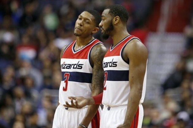 Washington Wizards guard Bradley Beal (3) and Washington Wizards guard John Wall (2) talk during a break in the first half of an NBA basketball game against the Charlotte Hornets, Monday, Feb. 2, 2015, in Washington. (AP Photo/Alex Brandon)