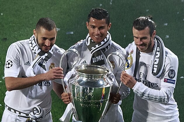 MADRID, SPAIN - MAY 29: Cristiano Ronaldo (2ndL) of Real Madrid CF holds the trophy as he poses for a picture with his teammates Karim Benzema (L) and Gareth Bale (R) during the celebration with their fans at Santiago Bernabeu Stadium the day after winning the UEFA Champions League Final match against Club Atletico de Madrid on May 29, 2016 in Madrid, Spain. Real Madrid CF is the only European football team with 11 European Cups (Photo by Gonzalo Arroyo Moreno/Getty Images)