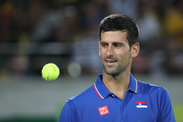 Aug 7, 2016; Rio de Janeiro, Brazil; Novak Djokovic (SRB) catches a ball during his match against Juan Martin Del Potro (ARG, not pictured) during the men's singles in the Rio 2016 Summer Olympic Games at Olympic Tennis Centre. Mandatory Credit: Jeff Swinger-USA TODAY Sports