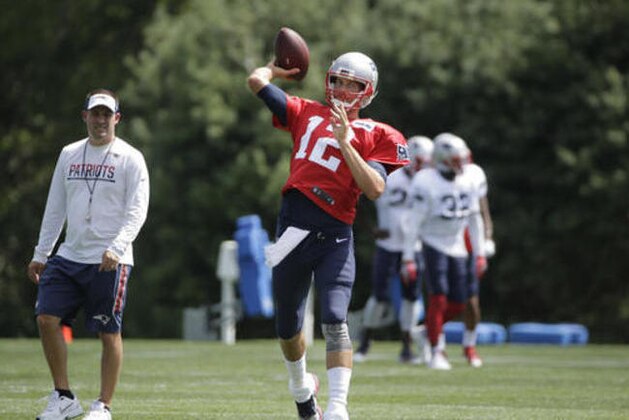 New England Patriots quarterback Tom Brady (12) winds up for a throw as offensive coordinator Josh McDaniels, left, watches during an NFL football training camp practice with the Chicago Bears, Monday, Aug. 15, 2016, in Foxborough, Mass. (AP Photo/Steven Senne)