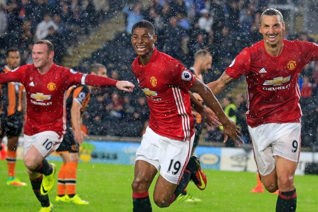 Manchester United's English striker Marcus Rashford (C) celebrates with Manchester United's Swedish striker Zlatan Ibrahimovic (R) and Manchester United's English striker Wayne Rooney (L) after scoring their late winning goal during the English Premier League football match between Hull City and Manchester United at the KCOM Stadium in Kingston upon Hull, north east England on August 27, 2016.
Manchester united won the game 1-0. / AFP / Lindsey PARNABY / RESTRICTED TO EDITORIAL USE. No use with unauthorized audio, video, data, fixture lists, club/league logos or 'live' services. Online in-match use limited to 75 images, no video emulation. No use in betting, games or single club/league/player publications.  /         (Photo credit should read LINDSEY PARNABY/AFP/Getty Images)