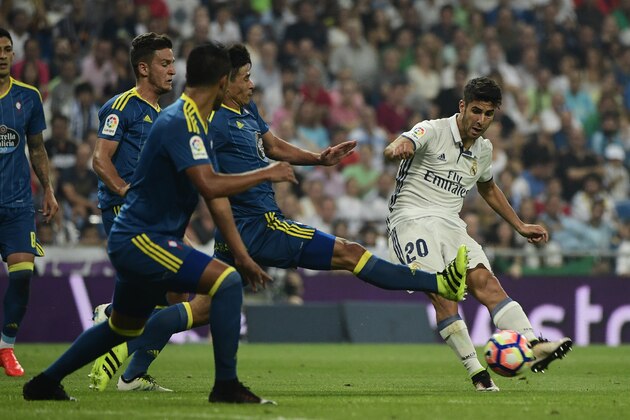 Real Madrid's midfielder Marco Asensio (R) kicks the ball under oposition by Celta Vigo's Argentinian midfielder Augusto Fernandez during the Spanish league football match Real Madrid CF vs RC Celta de Vigo at the Santiago Bernabeu stadium in Madrid on August 27, 2016. / AFP / PIERRE-PHILIPPE MARCOU        (Photo credit should read PIERRE-PHILIPPE MARCOU/AFP/Getty Images)