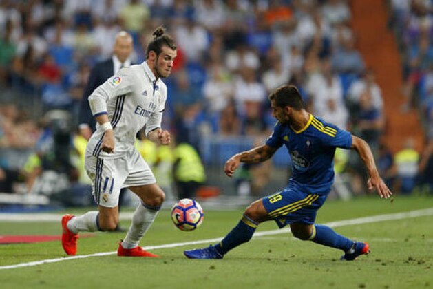 Real Madrid's Gareth Bale, left, tussles for the ball with Celta's Jonny Castro during the Spanish La Liga soccer match between Real Madrid and Celta Vigo at the Santiago Bernabeu stadium in Madrid, Saturday, Aug. 27, 2016. (AP Photo/Francisco Seco)
