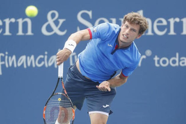Pablo Carreno Busta, of Spain, serves to Gael Monfils, of France, returns on the fourth day of the Western & Southern Open tennis tournament, Tuesday, Aug. 16, 2016, in Mason, Ohio. (AP Photo/John Minchillo)