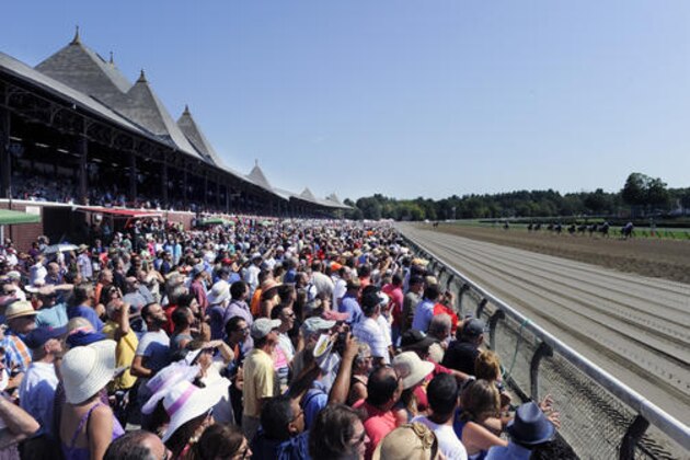 Race fans watch the first race prior to the Travers Stakes horse race at Saratoga Race Course in Saratoga Springs, N.Y., Saturday, Aug. 27, 2016. Reckling with Richard Santana, Jr. aboard won the race. (AP Photo/Hans Pennink)