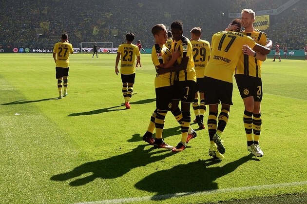Dortmund's Gabonese striker Pierre-Emerick Aubameyang (2nd R) is congratulated by Dortmund's midfielder Andre Schuerrle (R) as they celebrate with teammates after scoring the 1-0 during the German first division Bundesliga football match of Borussia Dortmund vs FSV Mainz 05 in Dortmund, western Germany, on August 27, 2016.  / AFP / PATRIK STOLLARZ / RESTRICTIONS: DURING MATCH TIME: DFL RULES TO LIMIT THE ONLINE USAGE TO 15 PICTURES PER MATCH AND FORBID IMAGE SEQUENCES TO SIMULATE VIDEO. == RESTRICTED TO EDITORIAL USE == FOR FURTHER QUERIES PLEASE CONTACT DFL DIRECTLY AT + 49 69 650050
        (Photo credit should read PATRIK STOLLARZ/AFP/Getty Images)