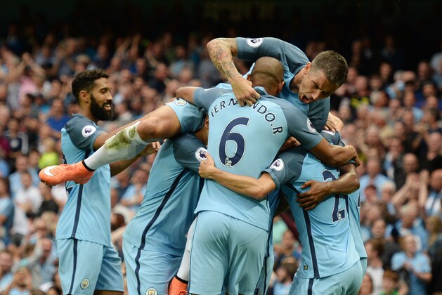 Manchester City's Serbian defender Aleksandar Kolarov (top) jumps on teammates after Manchester City's English midfielder Raheem Sterling scored during the English Premier League football match between Manchester City and West Ham United at the Etihad Stadium in Manchester, north west England, on August 28, 2016. / AFP / OLI SCARFF / RESTRICTED TO EDITORIAL USE. No use with unauthorized audio, video, data, fixture lists, club/league logos or 'live' services. Online in-match use limited to 75 images, no video emulation. No use in betting, games or single club/league/player publications.  /         (Photo credit should read OLI SCARFF/AFP/Getty Images)