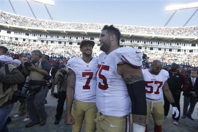 San Francisco 49ers quarterback Colin Kaepernick (7) speaks with San Francisco 49ers guard Alex Boone (75) after the second half of a divisional playoff NFL football game against the Carolina Panthers, Sunday, Jan. 12, 2014, in Charlotte, N.C. The San Francisco 49ers won 23-10. (AP Photo/John Bazemore)