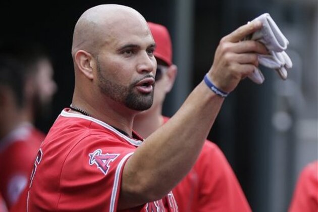 Los Angeles Angels' Albert Pujols talks with a teammate after scoring on a sacrifice fly ball hit by Jefry Marte during the sixth inning of a baseball game against the Detroit Tigers Sunday, Aug. 28, 2016, in Detroit. (AP Photo/Duane Burleson)