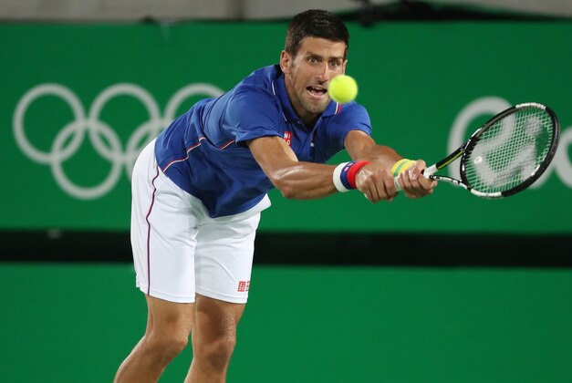 Aug 7, 2016; Rio de Janeiro, Brazil; Novak Djokovic (SRB) hits a forehand against Juan Martin Del Potro (ARG, not pictured) during the men's singles in the Rio 2016 Summer Olympic Games at Olympic Tennis Centre. Mandatory Credit: Jeff Swinger-USA TODAY Sports
