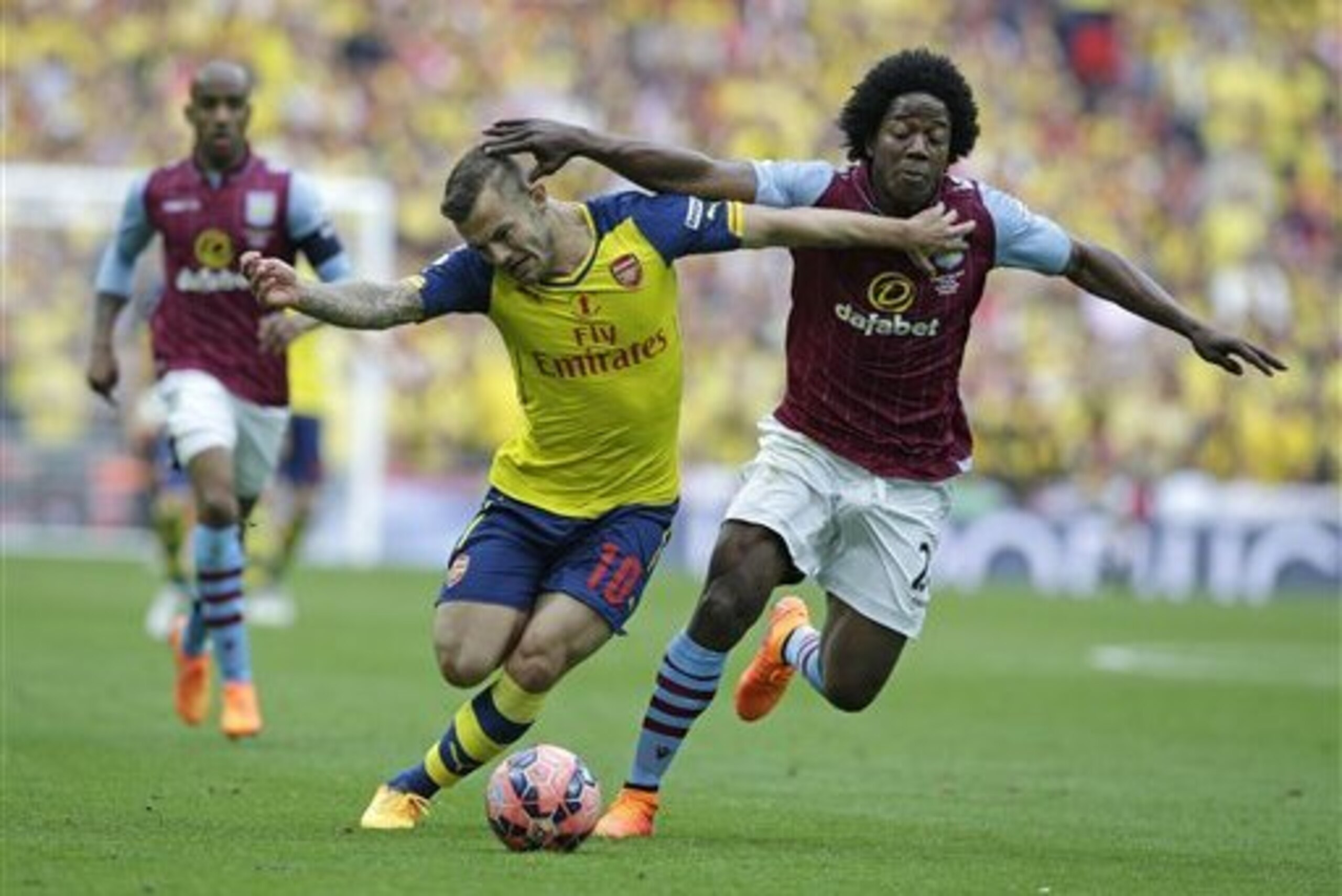 Arsenal's Jack Wilshere, left, is challenged by Aston Villa’s Carlos Sanchez during the English FA Cup final soccer match between Aston Villa and Arsenal at Wembley stadium in London, Saturday, May  30, 2015 . (AP Photo/Alastair Grant)