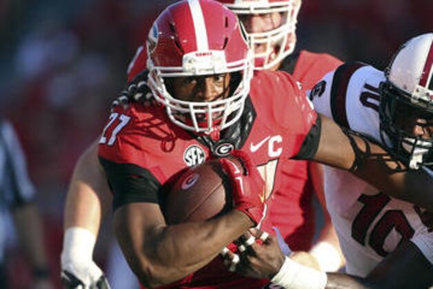 FILE - In this Sept. 19, 2015, file photo, Georgia running back Nick Chubb (27) tries to break free from South Carolina linebacker Skai Moore (10) during the first half of an NCAA college football game in Athens, Ga. Chubb had 747 yards rushing with seven TDs when he tore all the ligaments except the ACL in his left knee on the first play of the sixth game against Tennessee last season. Offensive coordinator Jim Chaney said Chubb looks strong in his comeback. (AP Photo/John Bazemore, File)