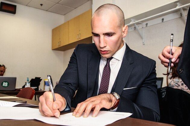 Rory MacDonald putting ink to his Bellator contract