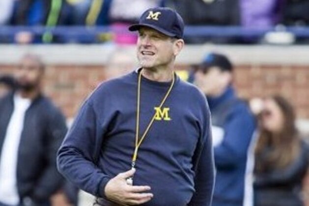 Michigan head coach Jim Harbaugh walks the field between downs in the NCAA college football team's annual Spring Game at Michigan Stadium in Ann Arbor, Mich., Friday, April 1, 2016. (AP Photo/Tony Ding)
