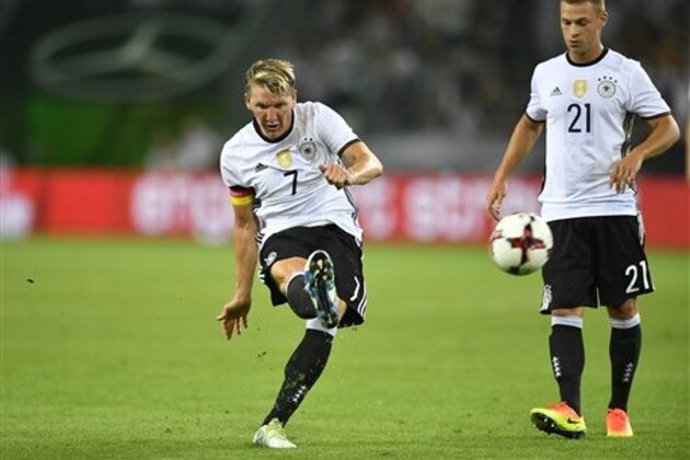 Germany's Bastian Schweinsteiger kicks the ball beside Joshua Kimmich, right, during a friendly soccer match between Germany and Finland in Moenchengladbach, Germany, Wednesday, Aug. 31, 2016. (AP Photo/Martin Meissner)