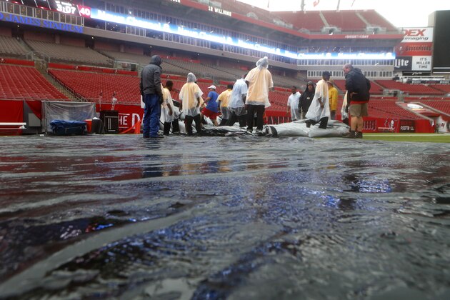 TAMPA, FL - AUGUST 31:  Members of the Tampa Bay Buccaneers' grounds crew remove a large tarp off of the playing field as heavy rains associated with Tropical Storm Hermine impact the Tampa Bay area prior to the start of and the Washington Redskins on August 31, 2016 at Raymond James Stadium in Tampa, Florida. (Photo by Brian Blanco/Getty Images)