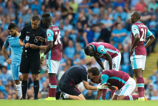 West Ham United's New Zealand defender Winston Reid, (2nd R), is treated after a clash with Manchester City's Argentinian striker Sergio Aguero (L) during the English Premier League football match between Manchester City and West Ham United at the Etihad Stadium in Manchester, north west England, on August 28, 2016. / AFP / JON SUPER / RESTRICTED TO EDITORIAL USE. No use with unauthorized audio, video, data, fixture lists, club/league logos or 'live' services. Online in-match use limited to 75 images, no video emulation. No use in betting, games or single club/league/player publications.  /         (Photo credit should read JON SUPER/AFP/Getty Images)